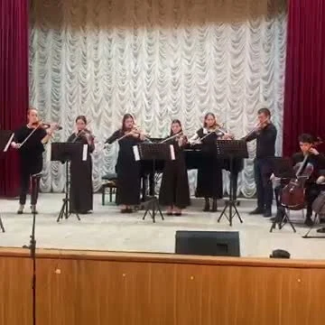 Ансамбль скрипачей и виолончелист на сцене фестиваля